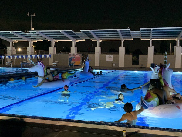 Students swimming and lounging on floaties.