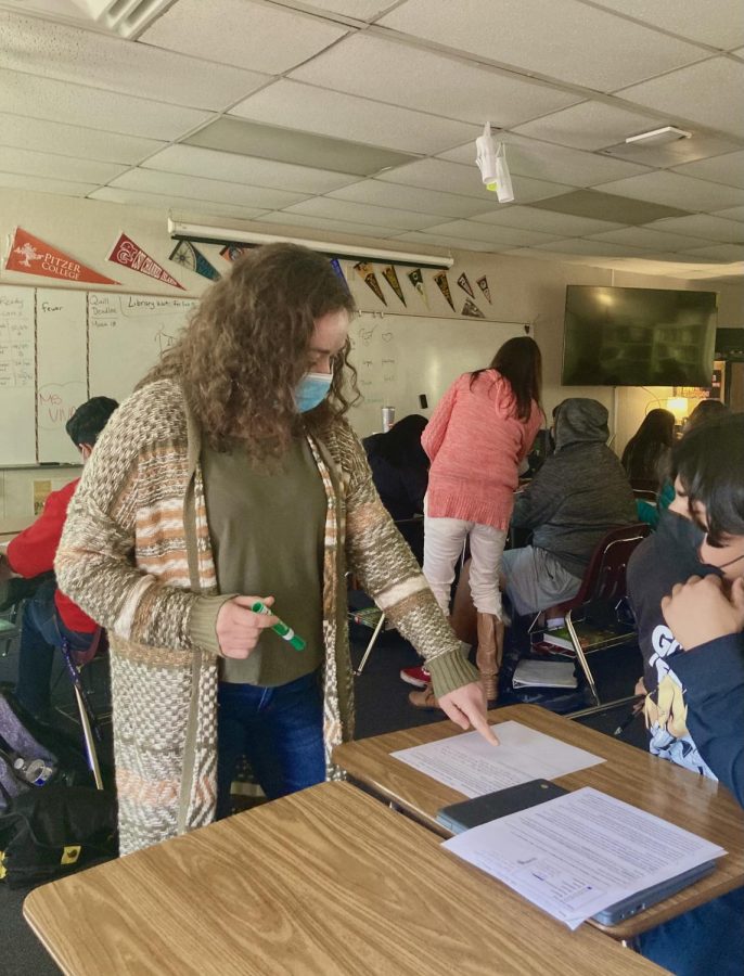 English teacher Amanda Vivas properly wears her mask per CDC guidelines while helping a student. 
