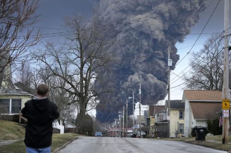 Blocks away from the crash site, a bystander watches as flames grow. Photo Credit:  MensHealth.com