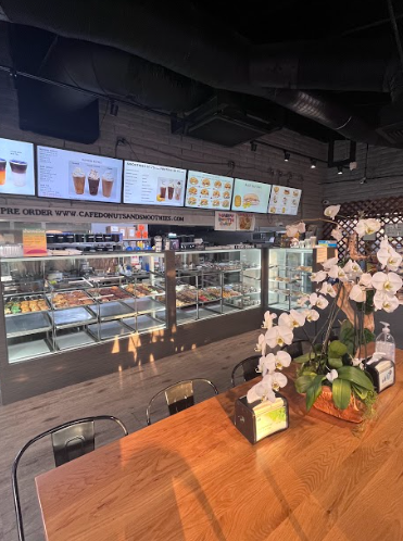 Inside look of Cafe Donuts and smoothies on a Tuesday afternoon, where a range of different goods are pictured along with well seating. 