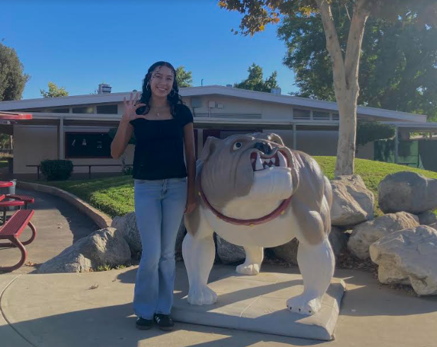 Becky Osorio next to bulldog statue after celebrating her CIF qualification. 