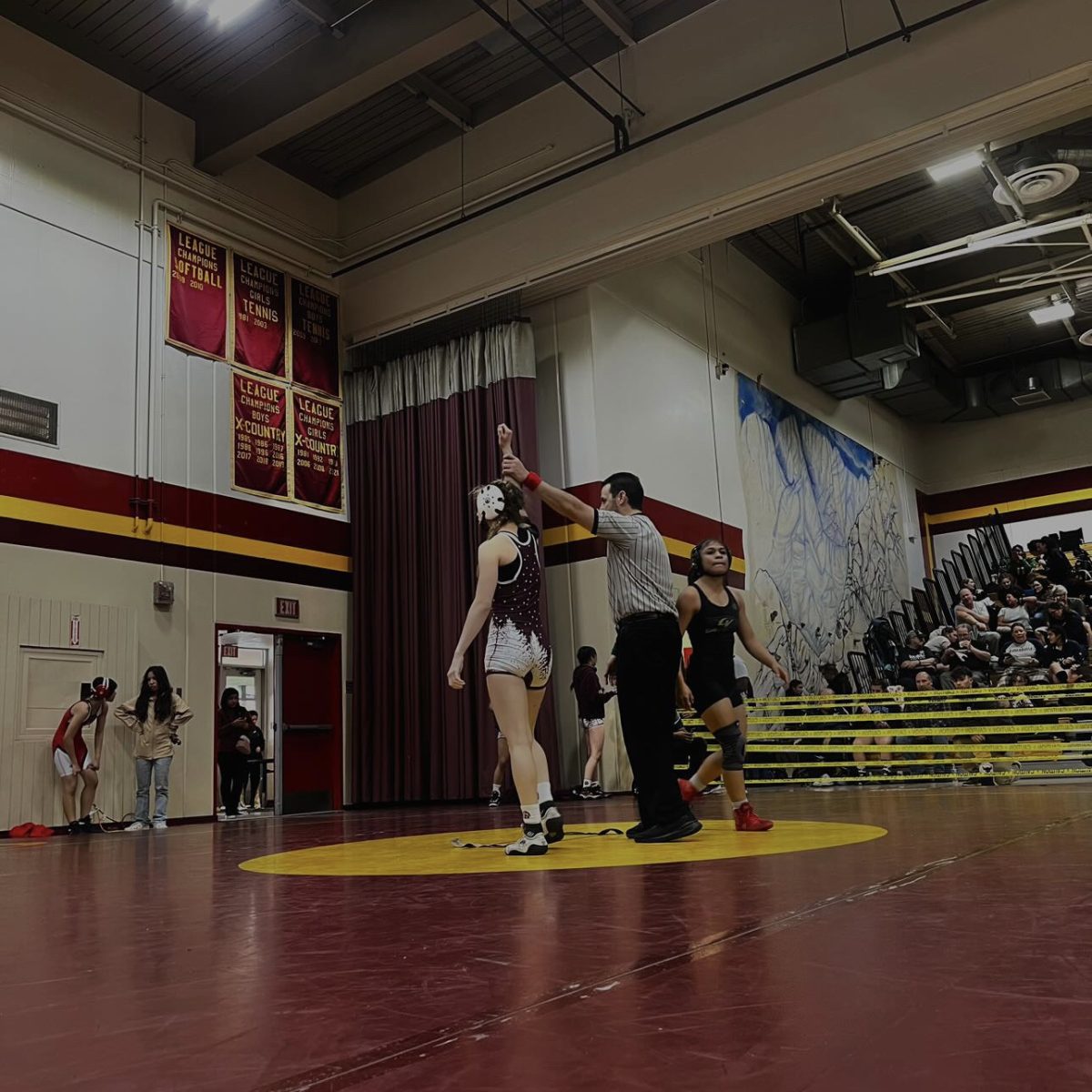 Carmouche stands to raise her hand as she triumphantly takes the win in her tournament on her senior night Jan. 23 at West Covina High Gym. 
