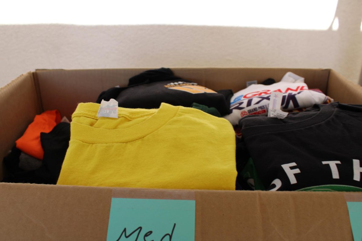 The top of the dress code cart, on Aug. 26, which contains a box full of school-approved shirts labeled by size for students to choose from. The shirts are recycled merchandise from previous school events.