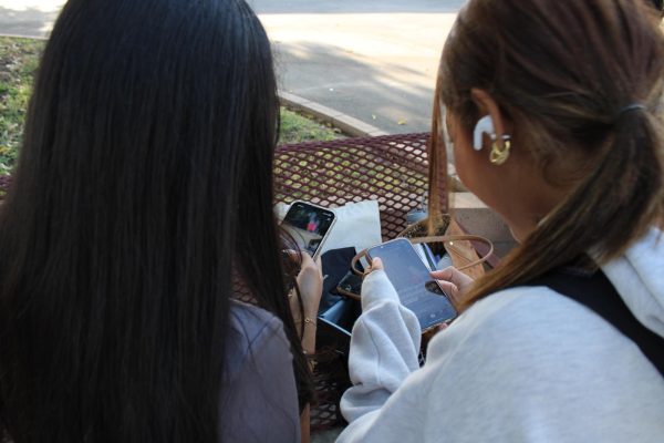 Juniors Hazel Borja and Katherine Barbosa-Calel check their social media and message their friends while waiting for school to start. “Phones are crucial to my daily routine… I feel a physical attachment to my phone since it’s so heavily integrated in my everyday routine” said Borja. 