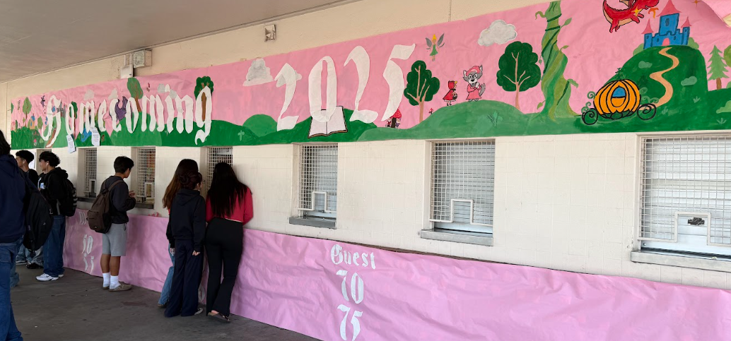 A poster of the homecoming theme of “fairytales” is displayed widely, covering the whole ASB store. As people buy their tickets, they discuss with one another as homecoming closes in. Photo by Xavier Cheng