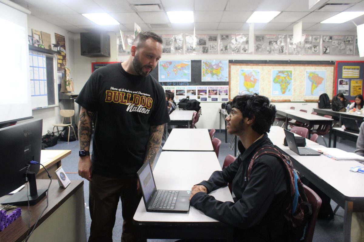Freshman Yousef Lubbadeh talks to his AP human geography teacher, Paul Gordon, about the class. Lubbadeh’s parents push him to be academically successful.