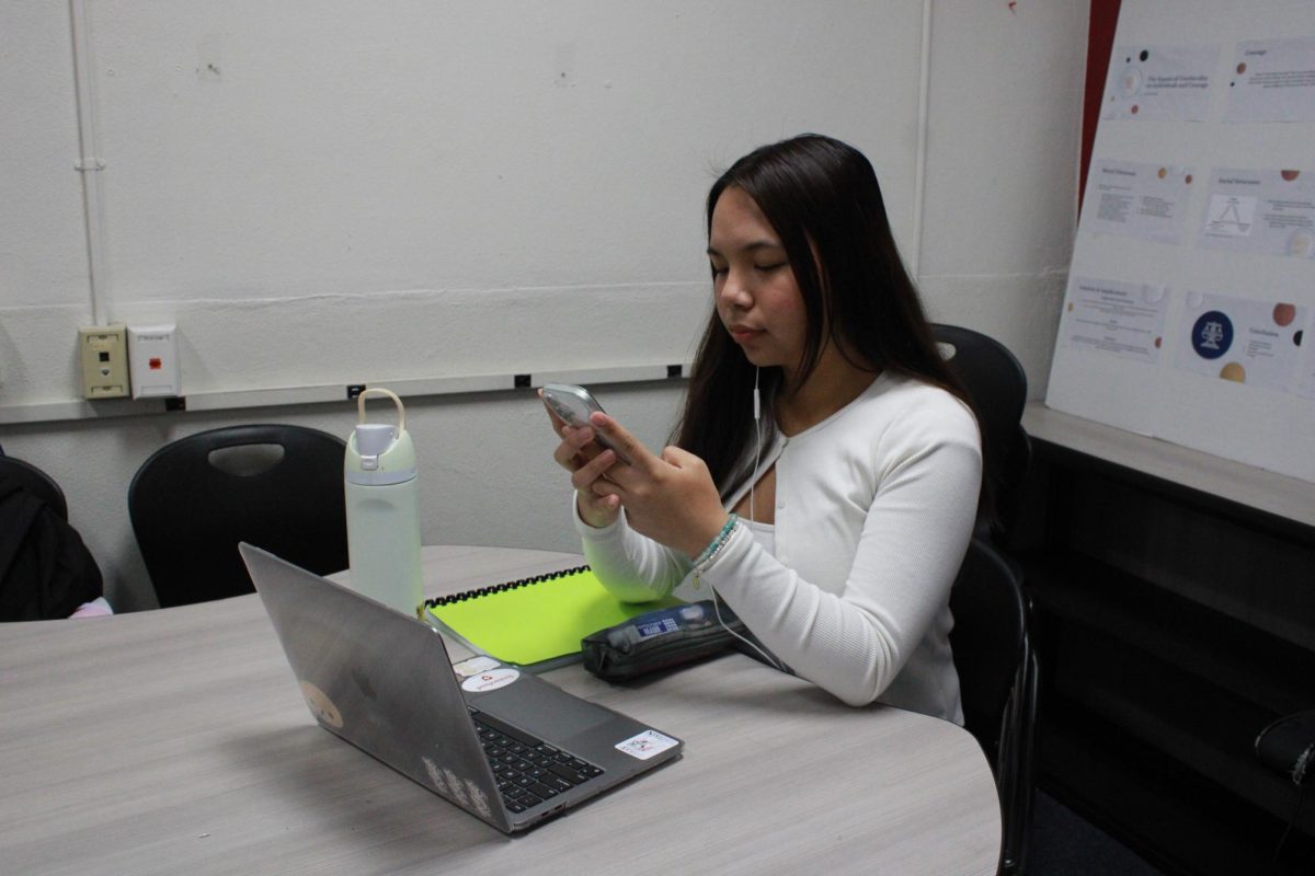 Junior Kristiene Felipe distracts herself by going on her phone instead of doing her schoolwork since she is less productive when experiencing seasonal depression.