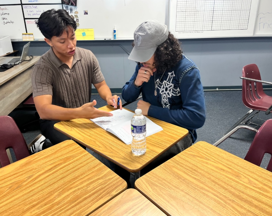 Vincent Buu guides a student through a problem in his business math class. “I just wanted to be part of that community and help having an interconnectedness of all of us together,” Buu said.
