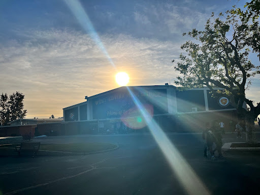 Students walk on campus under the afternoon sunset on Monday after school. As the fall time change sets in, earlier sunsets limit the daylight available for after-school activities.