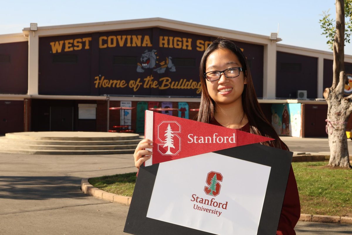 Senior Julie Liu stands in the quad with a Stanford University flag. Liu was accepted to Stanford through QuestBridge’s National College Match. Photo by Andrew Navidad