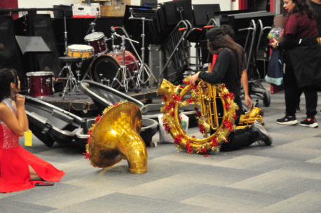 Sophomore and band member Jason Vela sets up his tuba in preparation for the parade. He decorated his instrument with a garland to follow the parade’s Christmas theme.