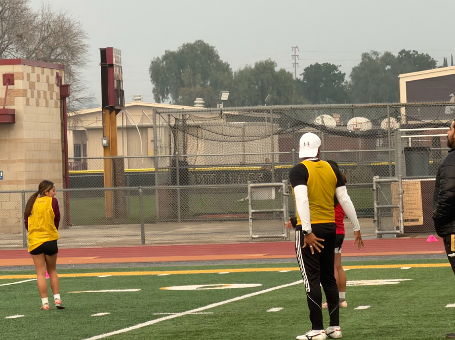 Girls’ soccer head coach Luis Osuna Zayas explains the correct position freshman player  Kimberly Gonzalez should stand at during last Friday’s game.