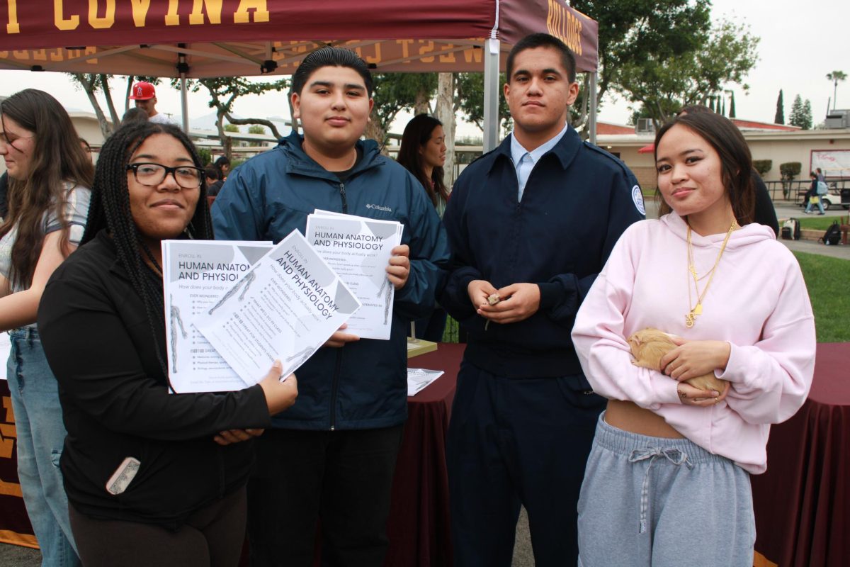 (left to right) Juniors Brianna Frederick, Isaiah Ramos, Javier Zamora and Colleen De Jesus at the human anatomy and physiology table hand out flyers to passersby. Flyers included details of the class environment as well as future opportunities in the field, encouraging interested students to stop by.