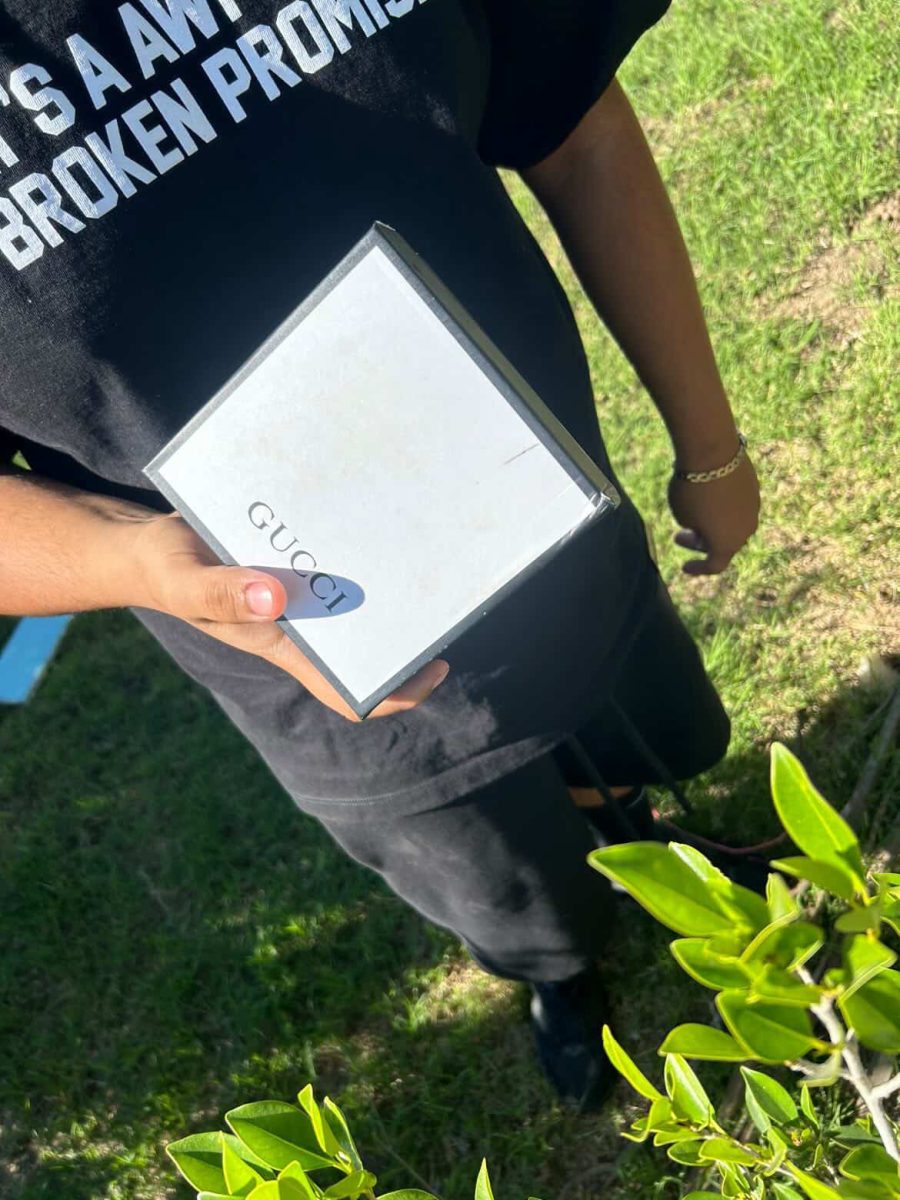 Fletcher makes a sale with a customer, selling a Gucci belt. They discuss prices and product information over text and meet to exchange cash and the item. Photo courtesy of Christopher Fletcher