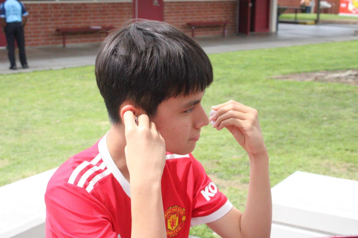Sophomore Steven Pham takes out his AirPods while listening to the World Cup song “Lighter.”